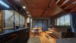 Une cuisine moderne avec des meubles en bois, un coin repas avec une table et des chaises, et un salon avec un canapé et un téléviseur.