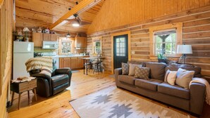 L’intérieur d’une cabane en rondins comprend un salon, une cuisine et un coin repas.