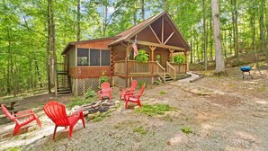 Une cabane dotée d’une terrasse, entourée d’une forêt.