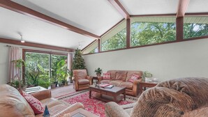 A spacious living room with a large window, a Christmas tree, leather sofas, and a red patterned rug. - Available Sept 7-10 & 13-17- Private Mini Resort w Indoor Pool & Sauna (West Olive)