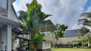 Un edificio con un acceso cubierto, un patio ajardinado y una escalera que conduce a un nivel superior.