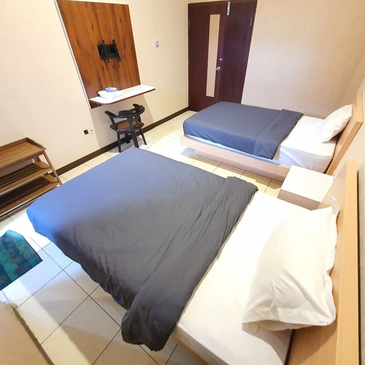 Habitación de hotel con dos camas, un escritorio y una silla.