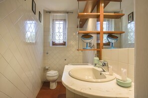 A bathroom with a toilet, sink, and mirror. - Villa Bellesi - Sweet Dreams in Florence (Firenze)