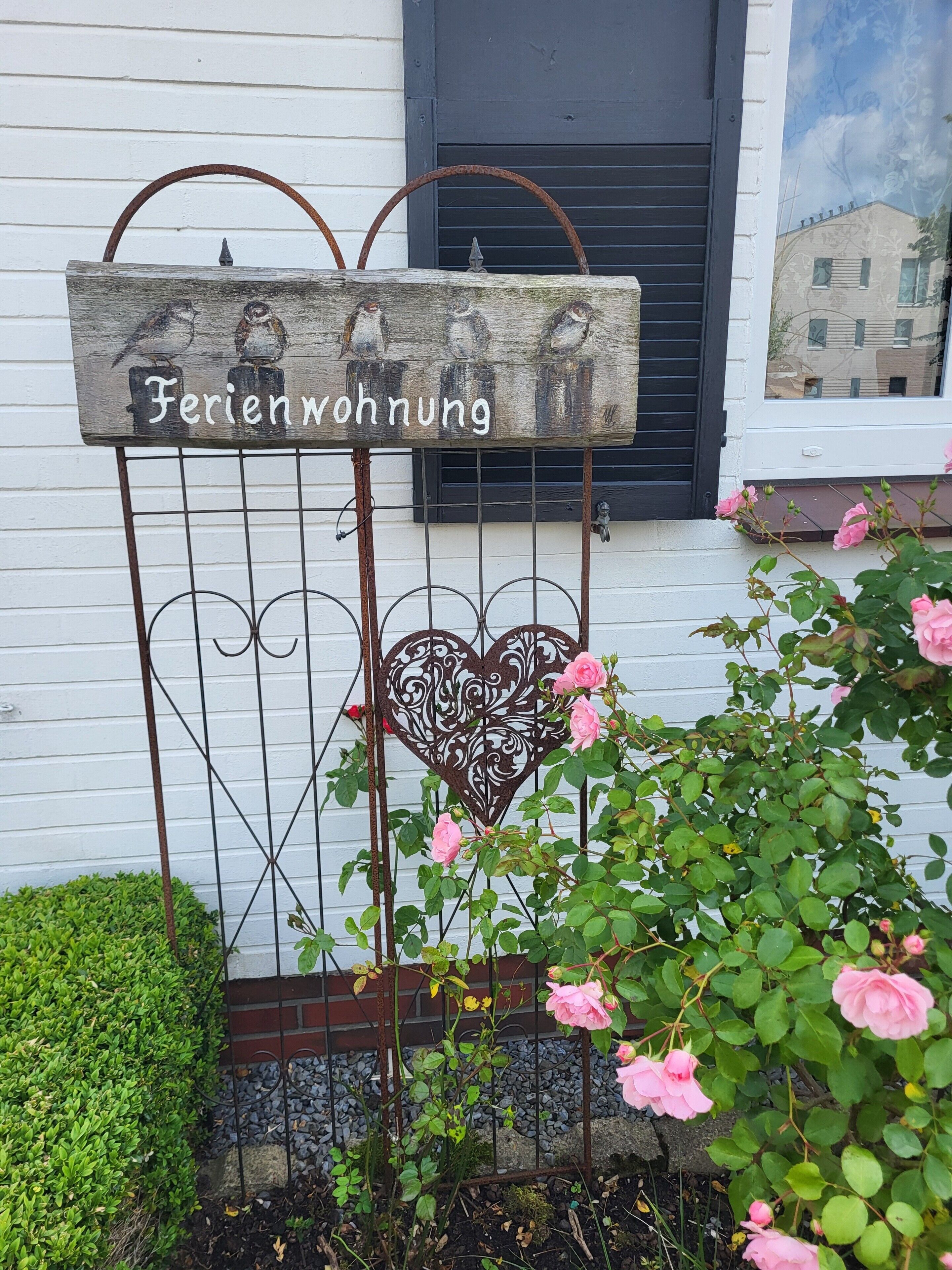 A metal sign with the text 'Ferienwohnung' and a heart-shaped decoration.