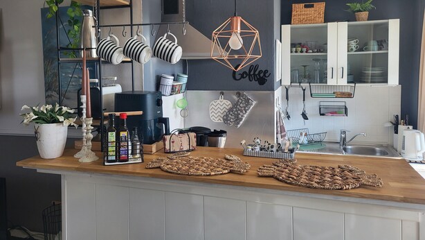 Eine Küche mit einer Kaffeestation, einer Kaffeemaschine und verschiedenen Küchengeräten.