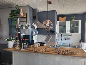 Eine Küche mit einer Kaffeestation, einer Kaffeemaschine und verschiedenen Küchengeräten.