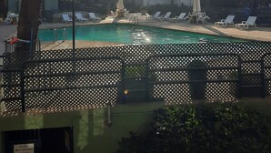 Ein Poolbereich mit Liegestühlen und einem Gebäude im Hintergrund.