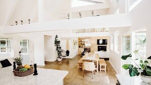 Amplia sala de estar integrada con una cocina, mesa de comedor y zona de estar.