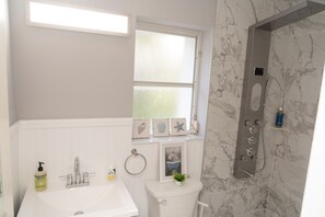 A bathroom with a white sink, a toilet, and a shower with marble tiles. - Studio- Sleep 2,Pool, Parking,5min walk to Beach 3 (Fort Lauderdale)