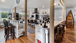 Une cuisine moderne dotée d’un îlot central, d’un coin bar et offrant une vue sur l’extérieur.