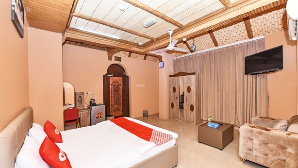 A bedroom with a bed, a sofa, a desk, and a TV. - OYO 139 Al Ghadeer Hotel Apartments (Barka)