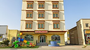 A hotel with a reception area, multiple windows, and a playground. - OYO 139 Al Ghadeer Hotel Apartments (Barka)