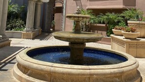 Un patio central con una fuente, rodeado de edificios con balcones y ventanas.