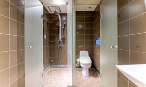 Une salle de bain avec douche, toilettes et lavabo.