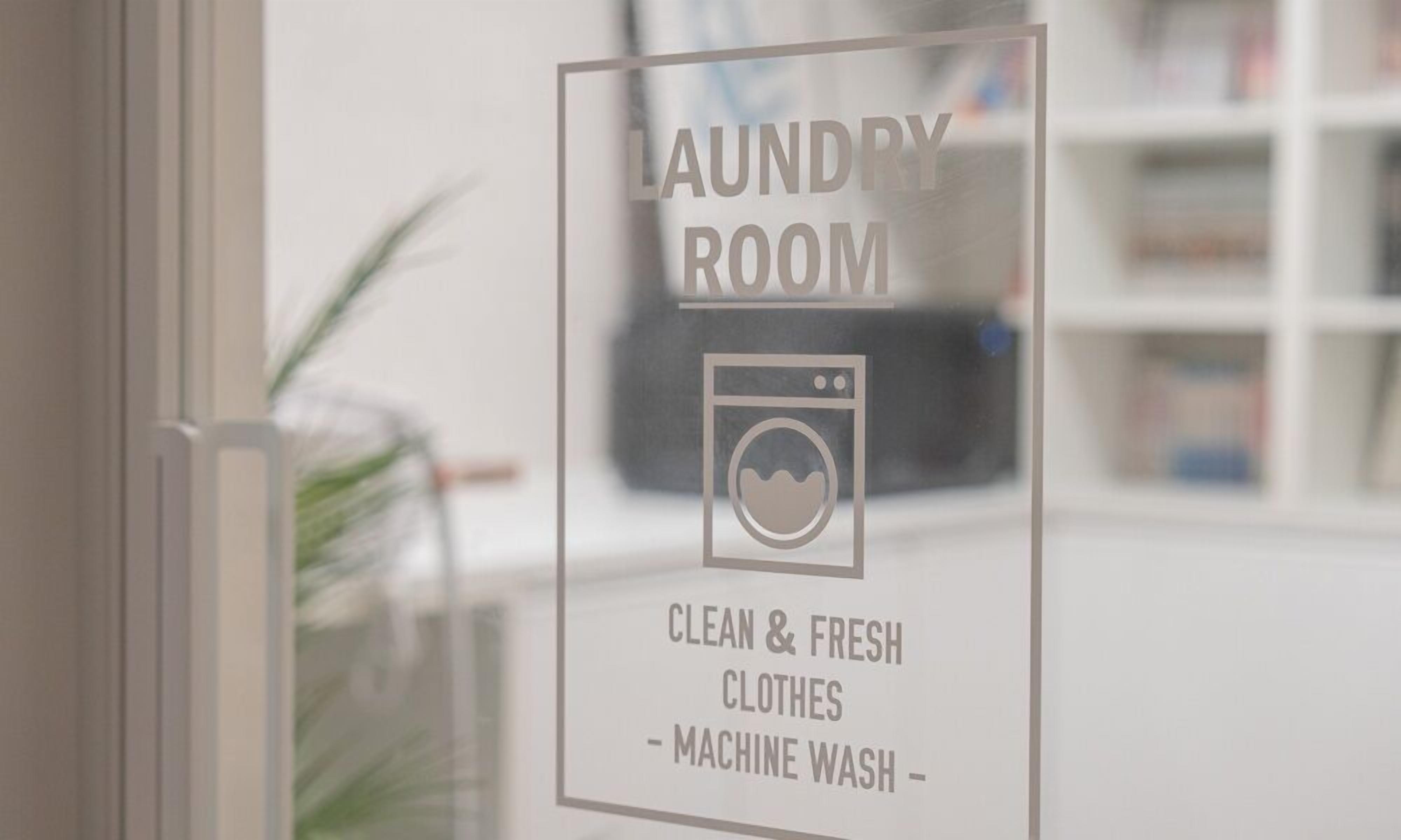 A sign indicating a laundry room with a symbol of a washing machine and text stating it is for clean and fresh clothes and machine wash.