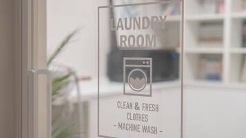 A sign indicating a laundry room with a symbol of a washing machine and text stating it is for clean and fresh clothes and machine wash.