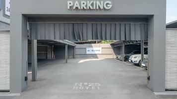 Entrada de estacionamiento a un hotel, con un letrero que indica 'PARKING' y otro con la indicación 'No. 25 HOTEL'.
