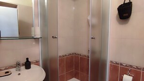 A bathroom with a glass-enclosed shower, a sink with a mirror, and a toilet. - Spacious studio apartment with a  terrace,parking,free WiFi and AC in Baška Voda (Baška Voda)
