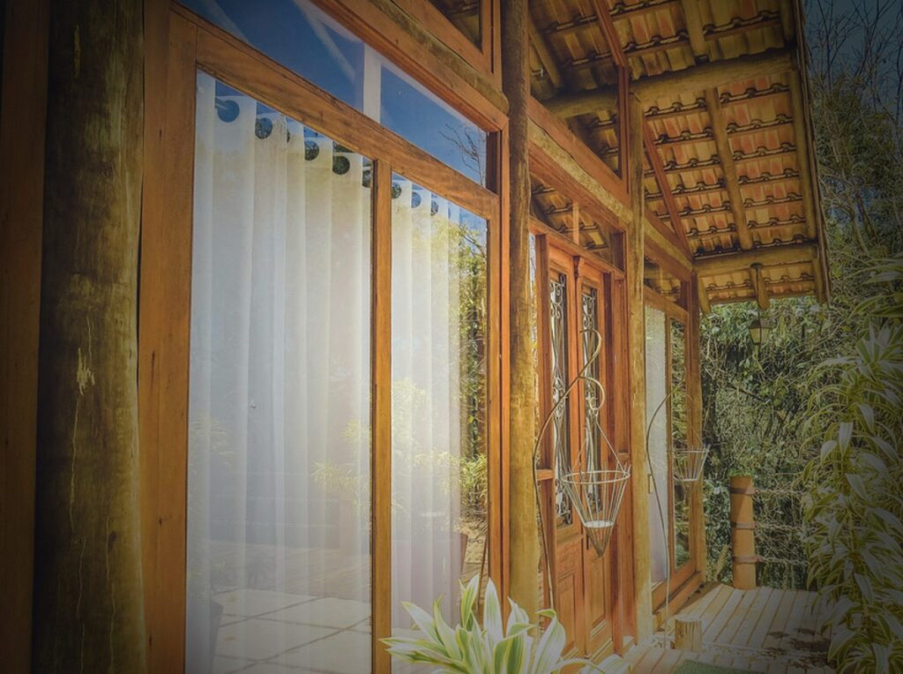 A wooden building with large windows and a covered porch.