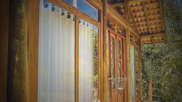 A wooden building with large windows and a covered porch.