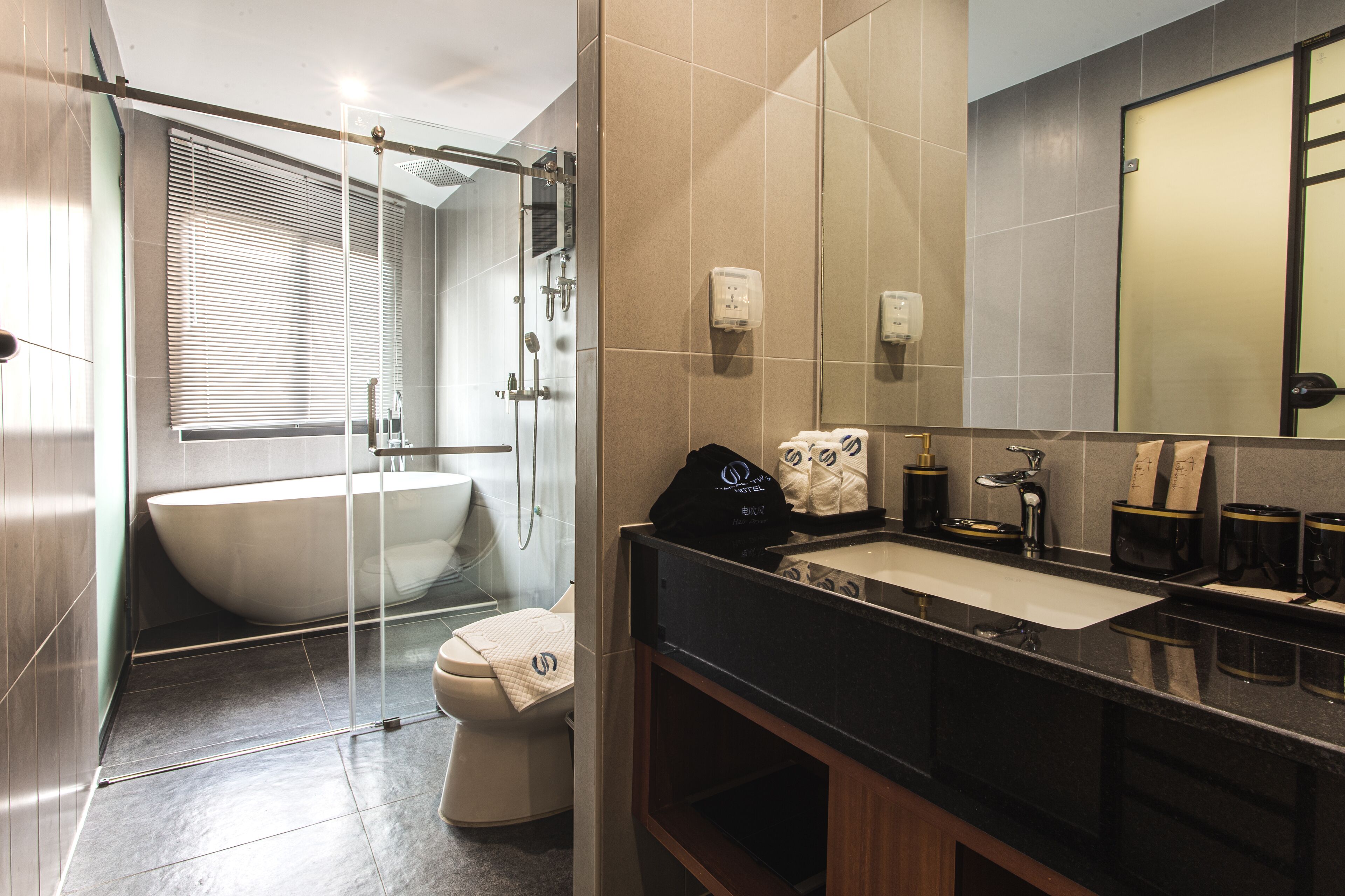 A modern bathroom with a freestanding bathtub, a glass-enclosed shower, and a vanity with a sink and mirror.
