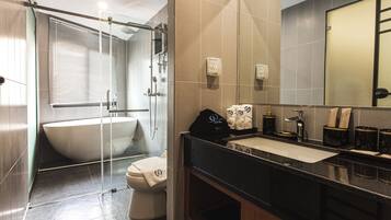 A modern bathroom with a freestanding bathtub, a glass-enclosed shower, and a vanity with a sink and mirror.