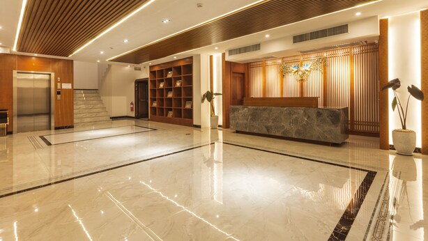 A modern lobby with a reception desk, a staircase, and a wooden panel ceiling. - Thapae Twins Hotel (Chiang Mai)