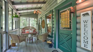 A porch with wicker furniture, a welcome sign, and a bear decoration. - Respite at Big Canoe - Wood-burning fireplace, bright interiors, Wifi (Jasper)
