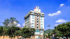 A multi-story hotel with a prominent sign at the top, large windows, and a view of surrounding greenery. - 7 Apple Hotel Jal Mahal Jaipur (Jaipur)