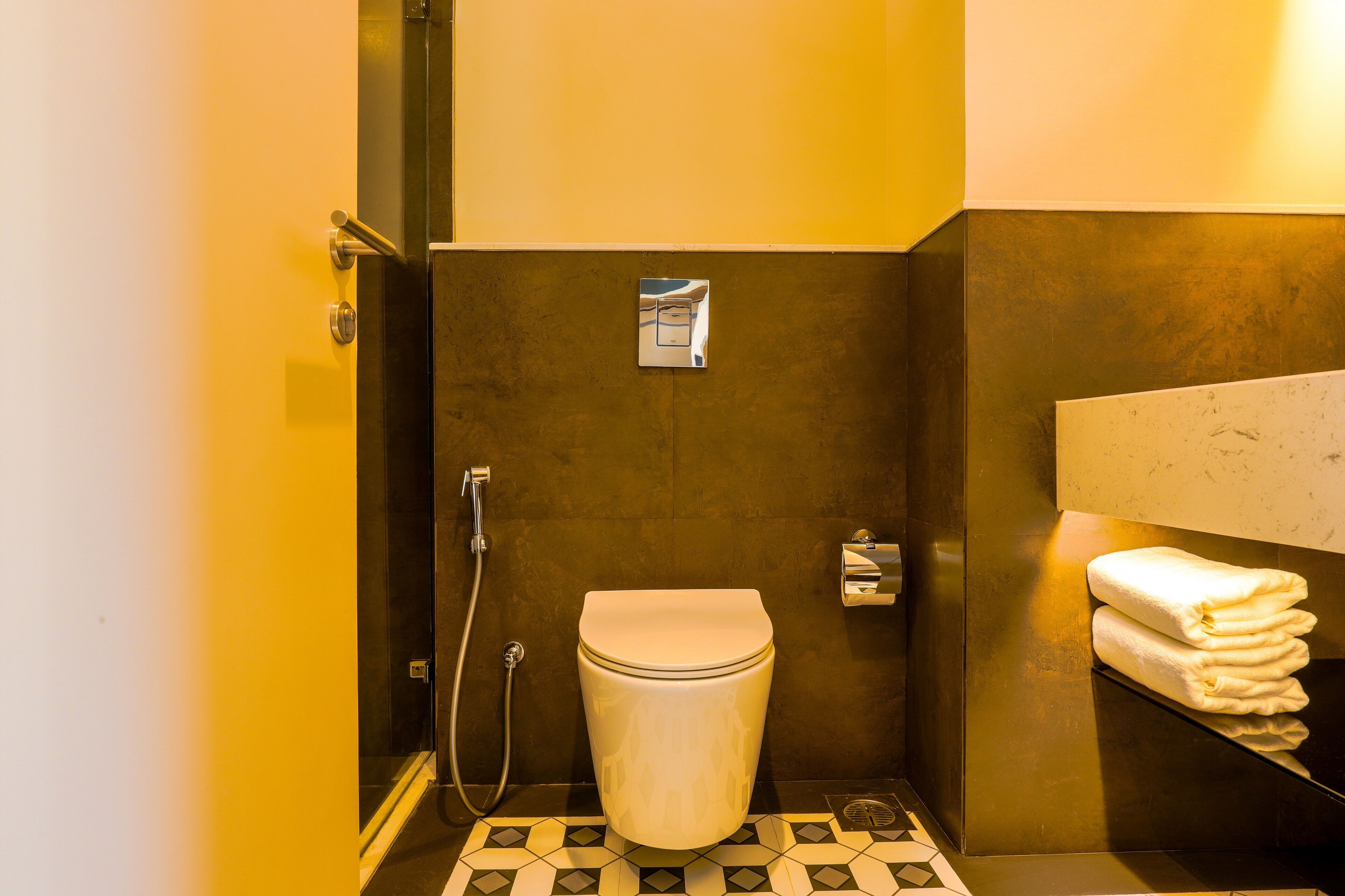 Un baño pequeño con inodoro, ducha y un perchero para toallas.