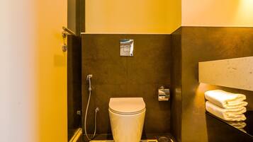 Un baño pequeño con inodoro, ducha y un perchero para toallas.