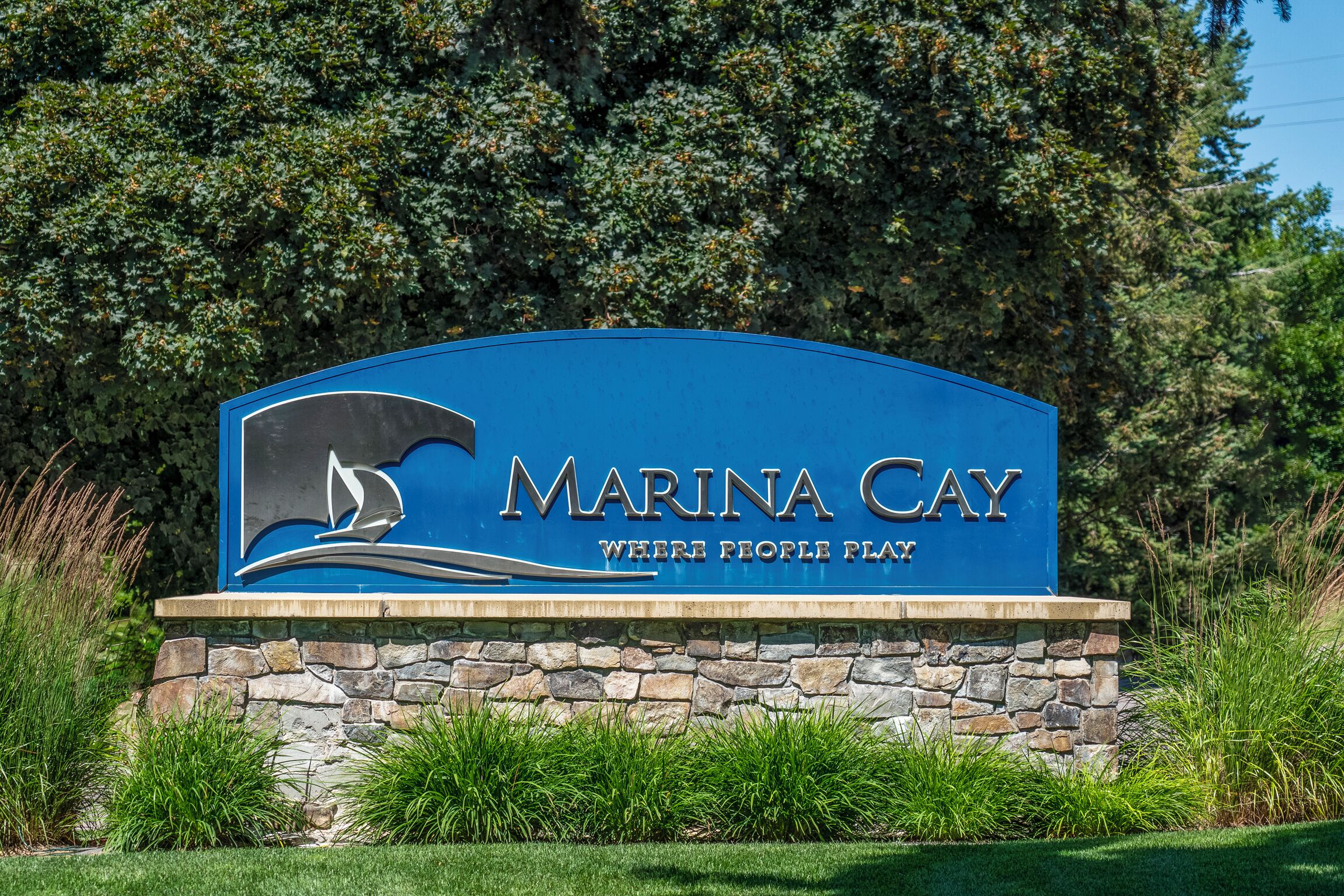 A sign for Marina Cay with a sailboat logo and the text "Marina Cay Where People Play".