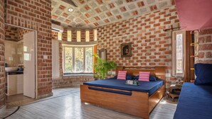 A bedroom with a brick wall, a wooden bed, a window, and a plant. - The Orchard Farm, Manesar- Luxury Pet- Friendly Farm with private pool & Jacuzzi (Para)