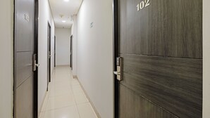 A hallway with doors numbered 117 and 102, leading to rooms. - City Biz Residence (Jakarta)