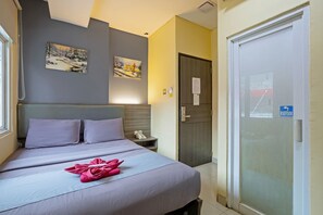 Relax in this stylish room with a comfortable bed, framed artwork, and a convenient nightstand.