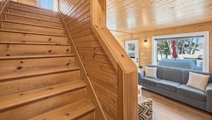 A wooden staircase leading to a living area with a sofa and a window. - Lakeside Retreat with Hot Tub (Windsor)