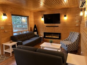 Smart-tv, een open haard, boeken en een stereo