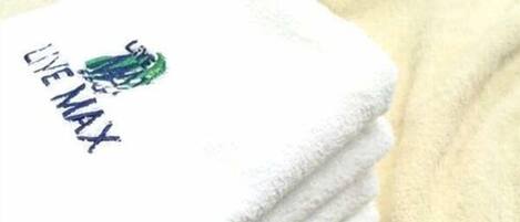 A stack of white towels with a logo and text on one of them.