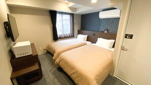 A hotel room with two beds, a desk with a computer, a window with curtains, an air conditioning unit, and a door with a sign. - Hotel Livemax Kamata Ekimae (Tokyo)