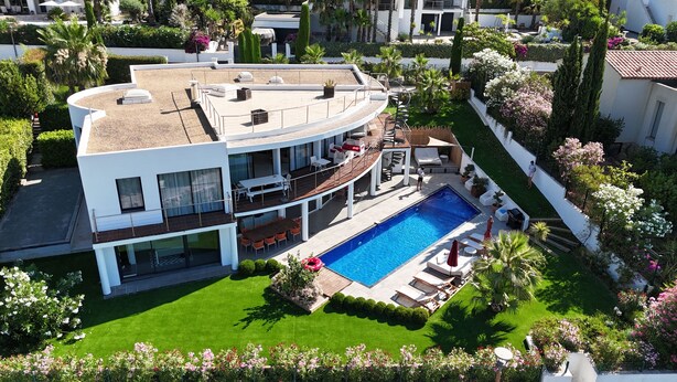 Une maison moderne à deux étages, dotée d’une piscine, d’un espace extérieur aménagé et d’un jardin bien entretenu.