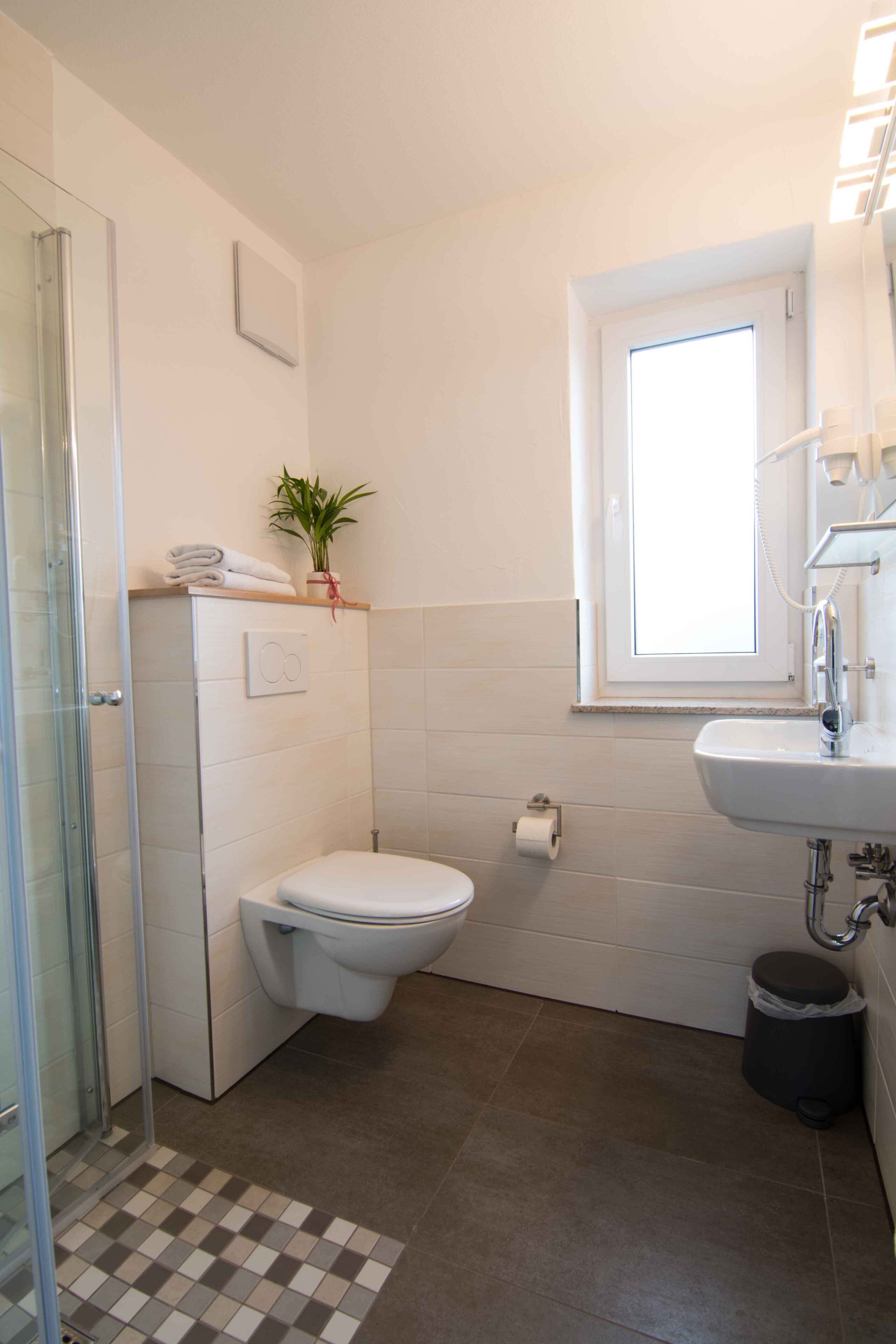 A modern bathroom with a toilet, sink, and shower.