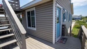 A wooden deck with a staircase leading to a house with beige siding and blue shutters. - Oceanside, Private Pool, Hot Tub, MIL Suite, KH529, Sea Turtle Sunrise (Kitty Hawk)
