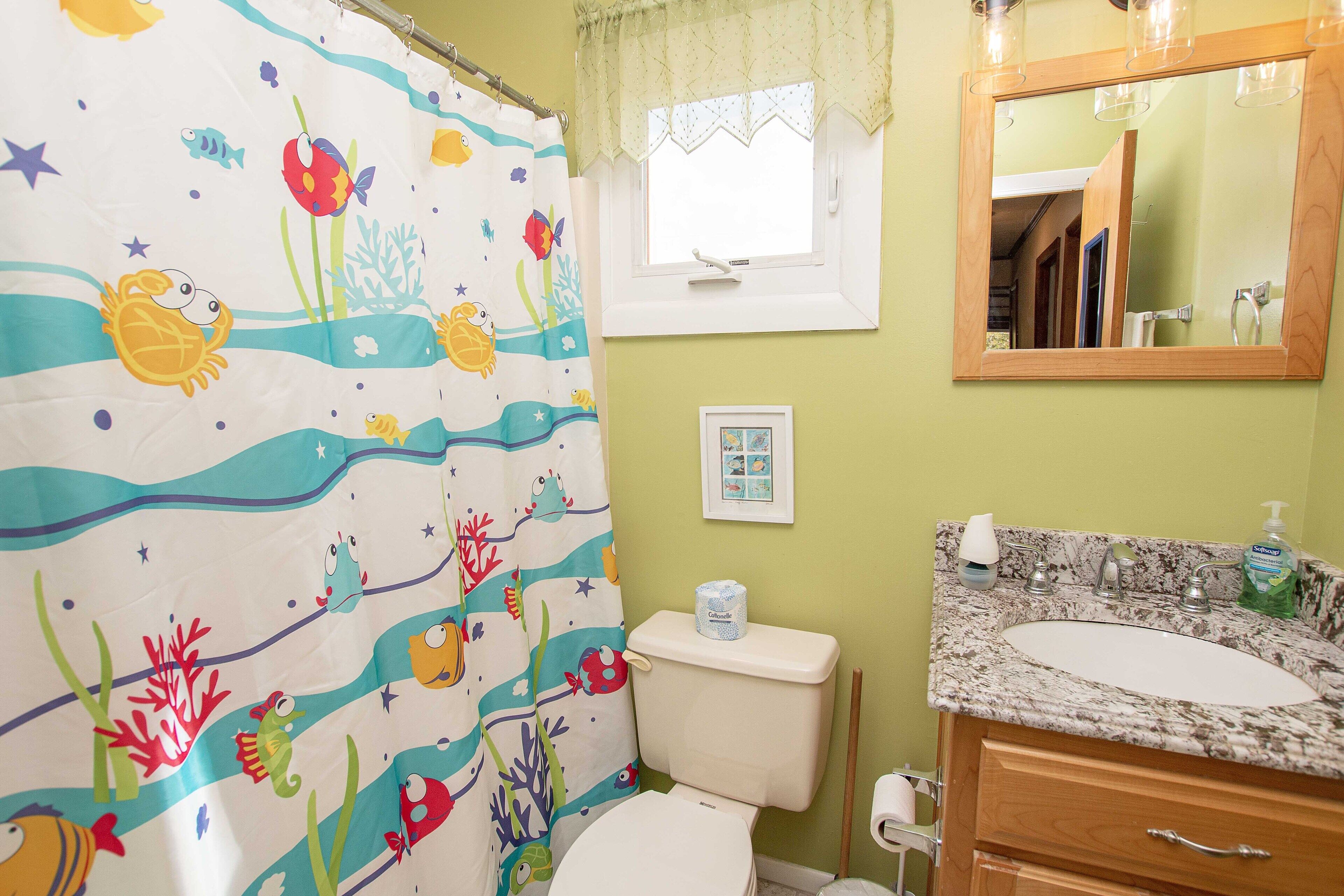 A bathroom with a toilet, sink, and mirror.