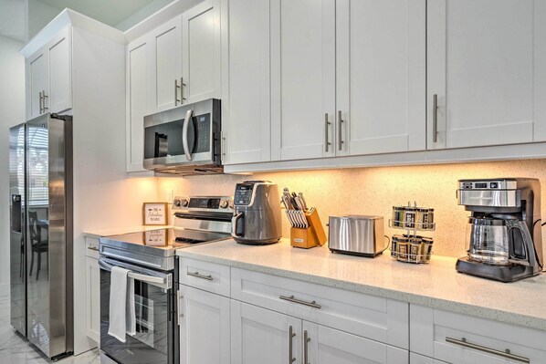 Enjoy cooking in this fully equipped kitchen with a refrigerator, microwave, oven, coffee maker, toaster, and knife block.