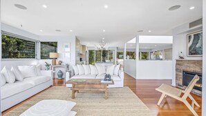 A spacious living room with a white sofa, a coffee table, and a fireplace.