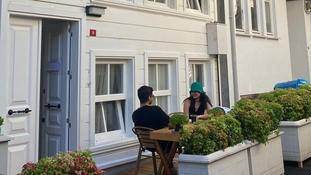 Ein zweistöckiges Gebäude mit einem Balkon und einem Schild, auf dem 'White Island Boutique Hotel' steht.