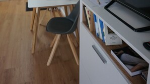 A modern living room with a flat-screen TV, a dining table with chairs, a bookshelf, and a door in the background. - HochgratBlick.modern.cozy.relaxed (Argenbühl)