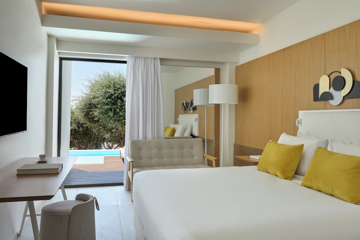 Une chambre d’hôtel moderne avec un grand lit, un bureau et une vue sur l’extérieur.