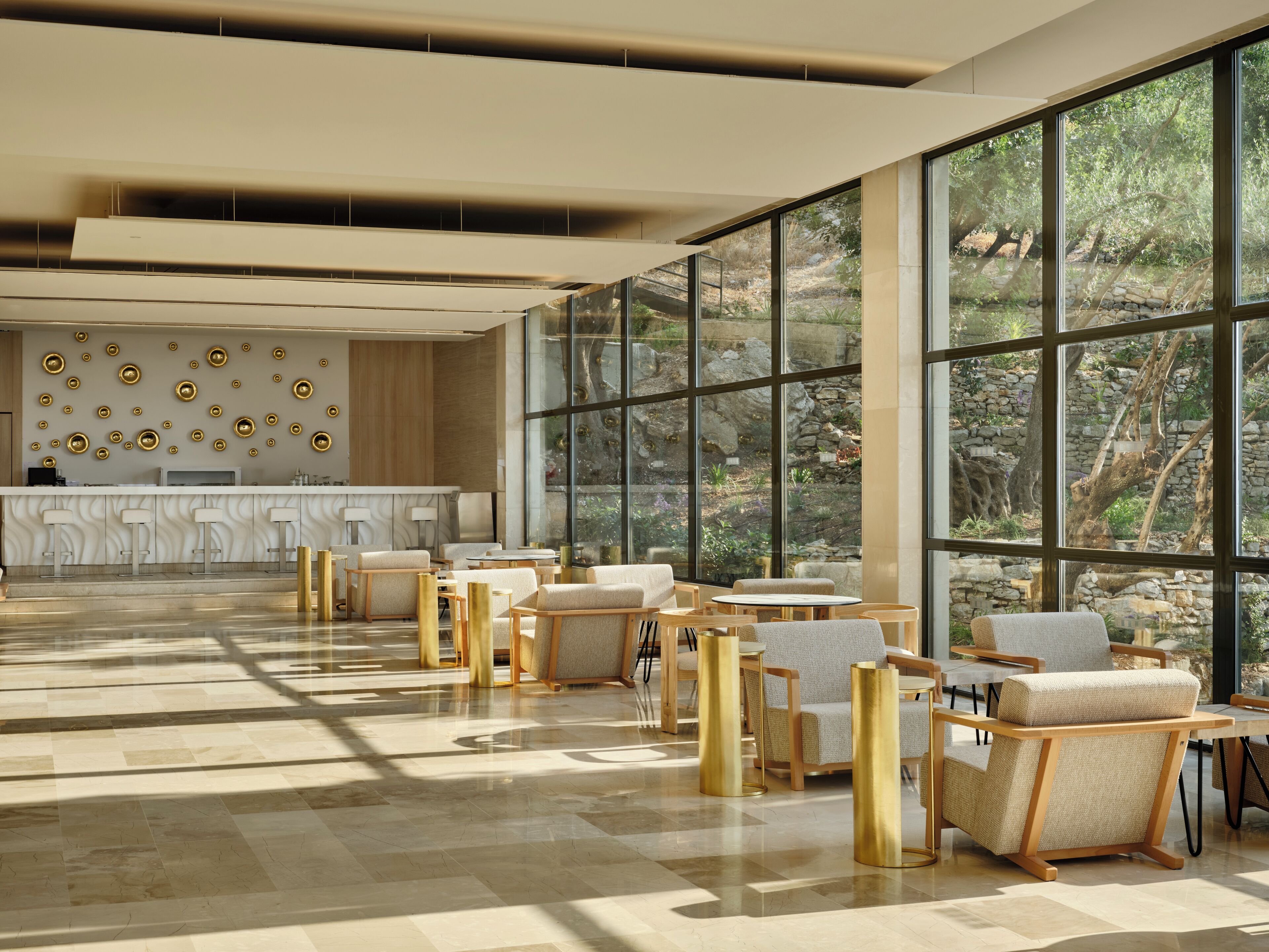 A spacious lobby with a reception desk, seating area, and large windows offering a view of the outdoors.