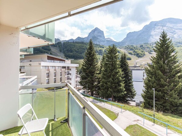 A balcony with a view of mountains and trees.